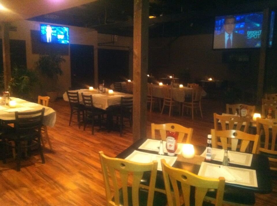 Dining room set with candles and white linens in the evening