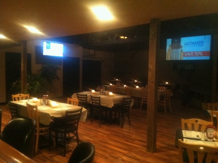 Wood-floored dining room with televisions above the tables