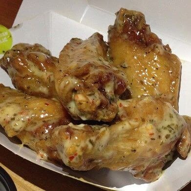 A basket of sauced chicken wings